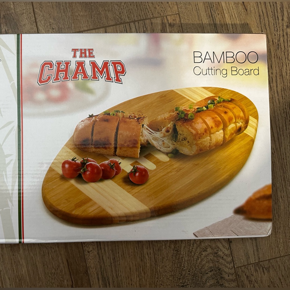 The champ bamboo cutting board in the shape of a football. New still in box.